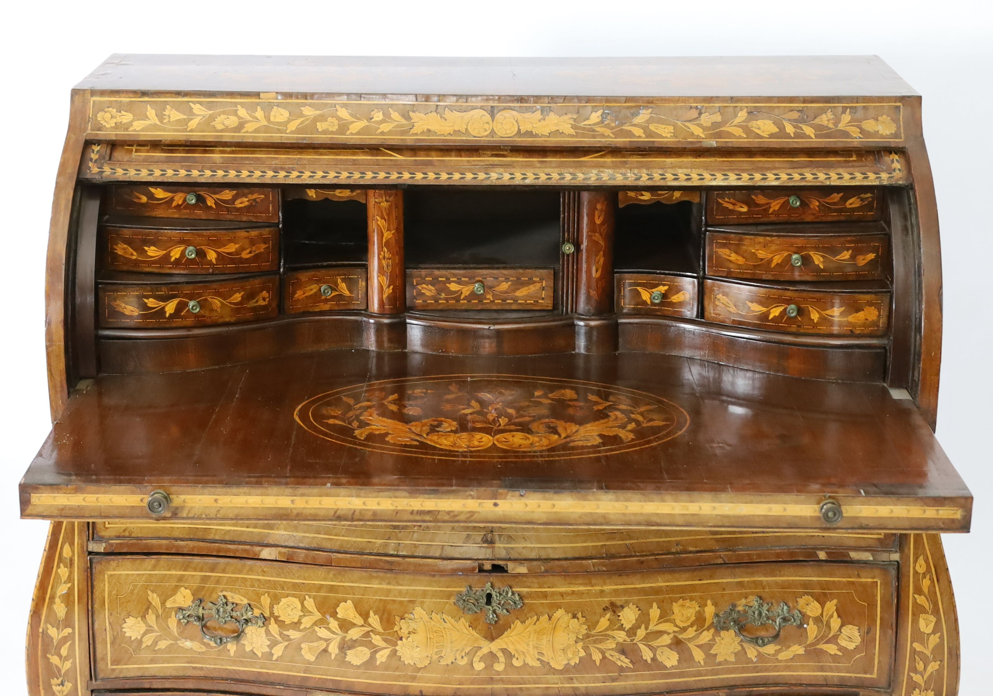 An early 19th century Dutch walnut and floral marquetry bombe cylinder bureau, W.133cm D.58cm H.122cm